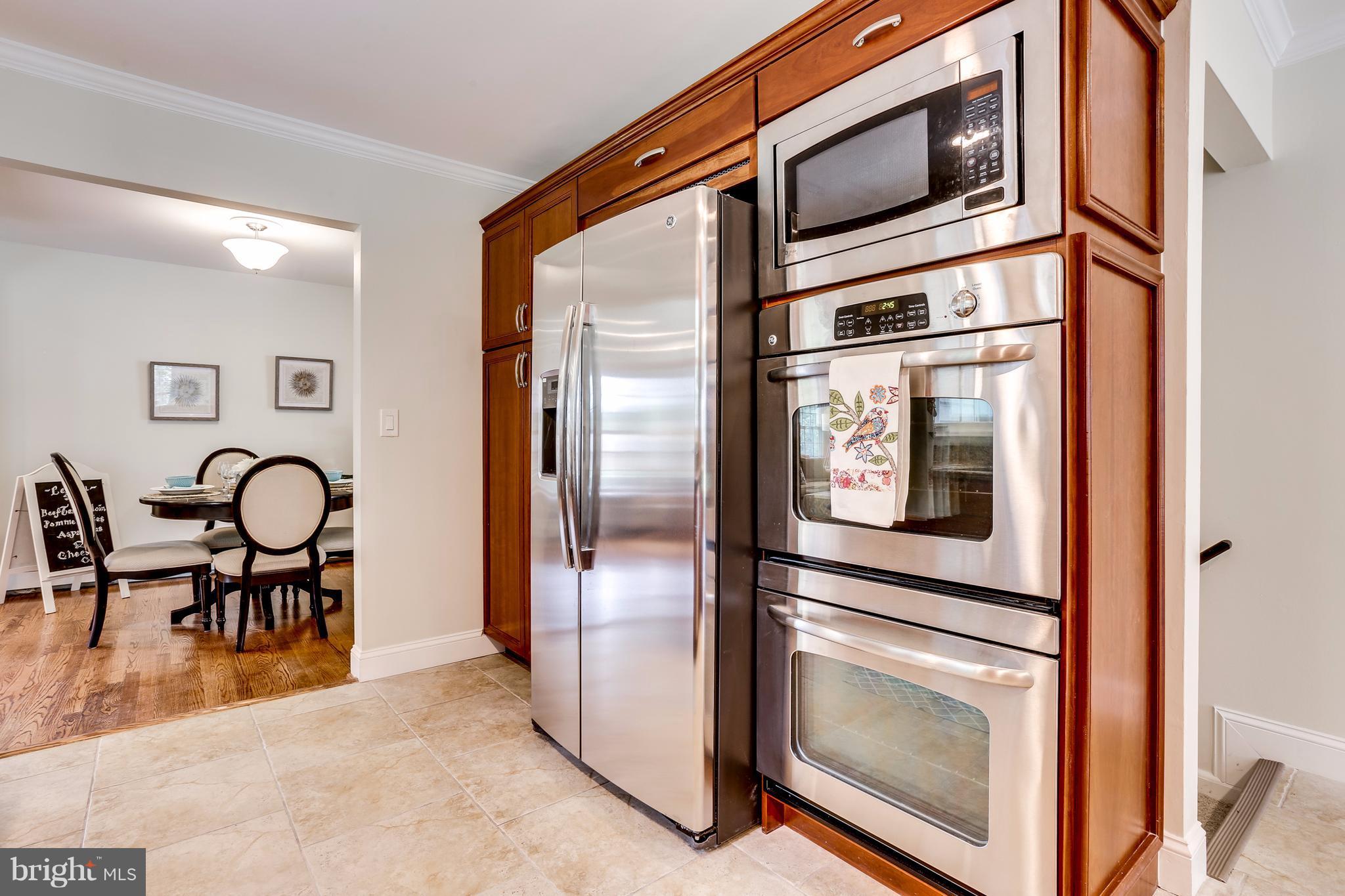 15407 Rowland Lane Silver Spring, MD 20905 - Photo 13 of 29 a open kitchen with stainless steel appliances granite countertop a stove top oven a sink and a refrigerator
