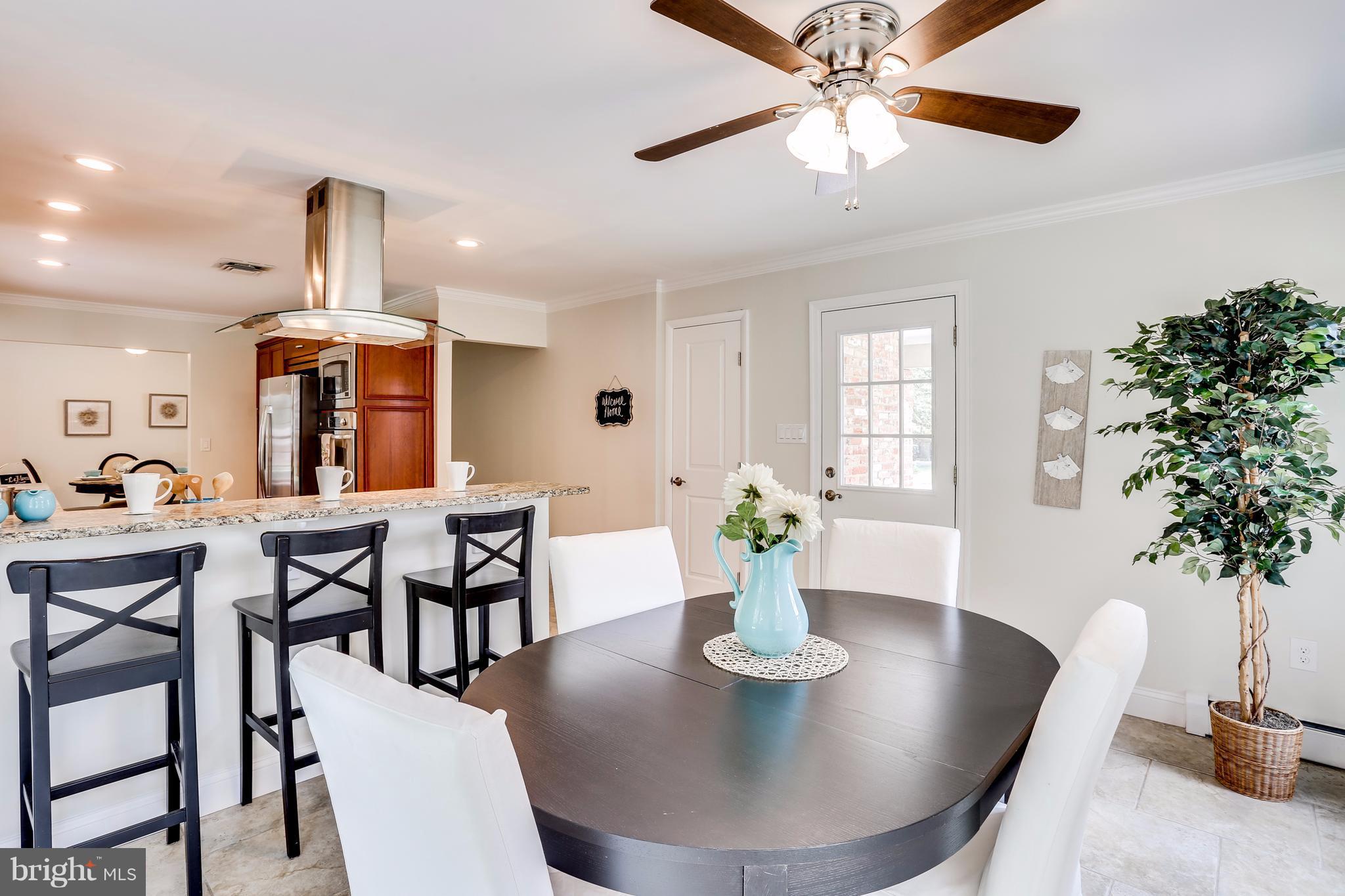 15407 Rowland Lane Silver Spring, MD 20905 - Photo 15 of 29 a dining room with furniture potted plants and wooden floor