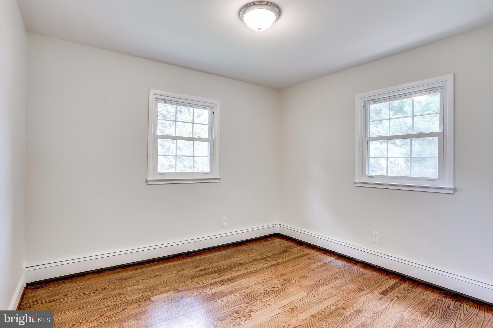 15407 Rowland Lane Silver Spring, MD 20905 - Photo 18 of 29 an empty room with wooden floor and windows