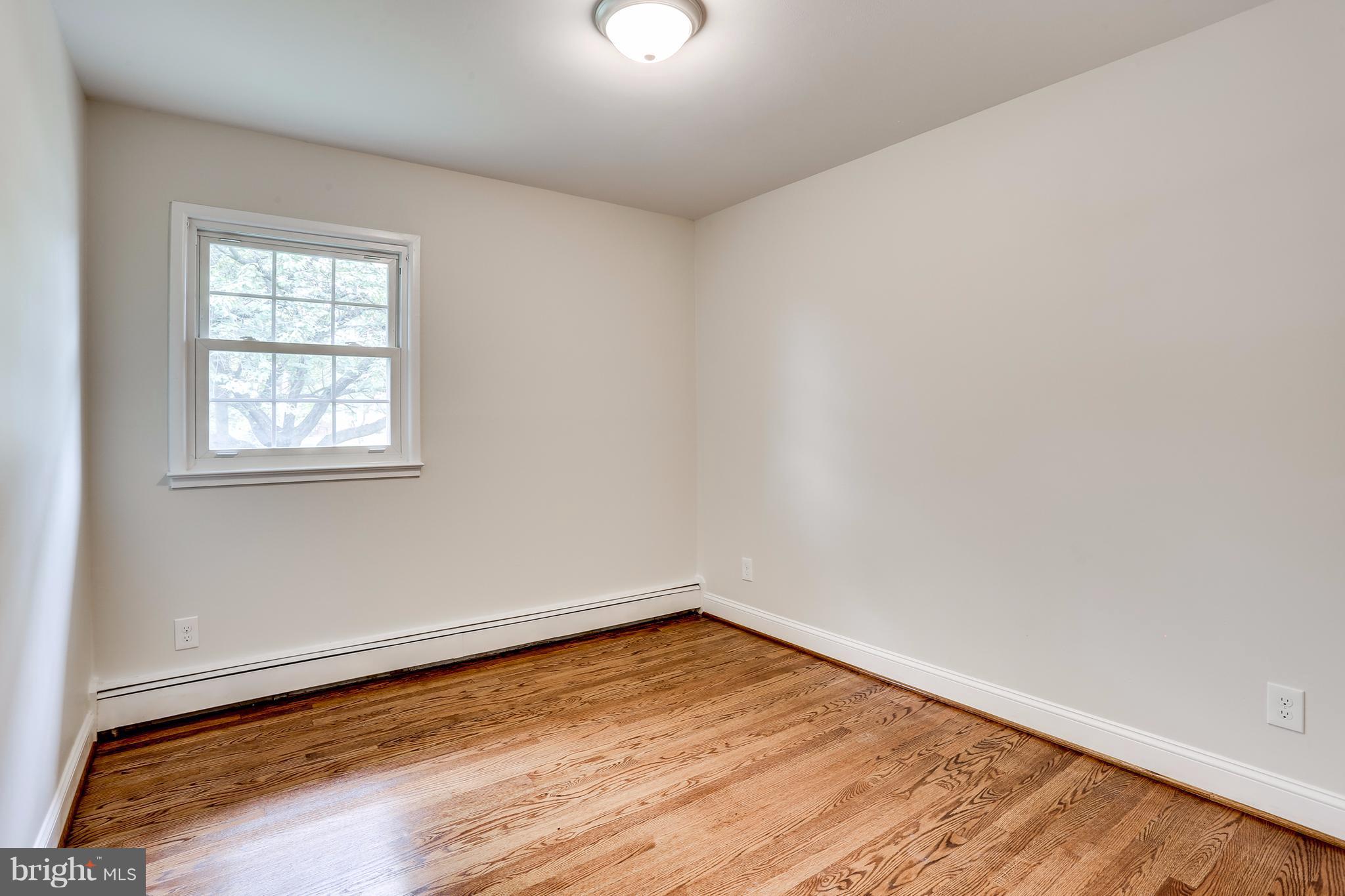 15407 Rowland Lane Silver Spring, MD 20905 - Photo 21 of 29 an empty room with wooden floor and windows