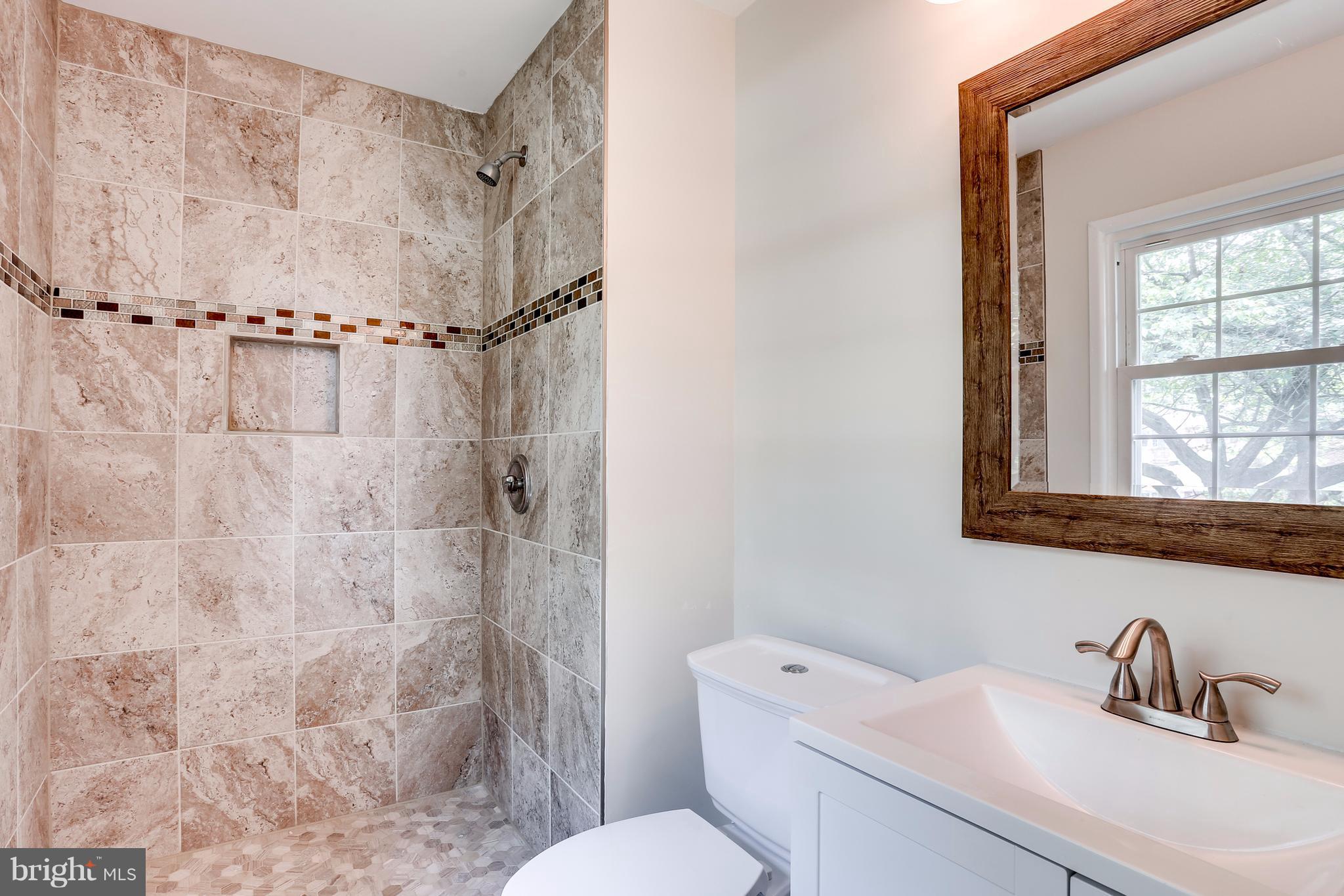15407 Rowland Lane Silver Spring, MD 20905 - Photo 26 of 29 a bathroom with a sink toilet a mirror and shower
