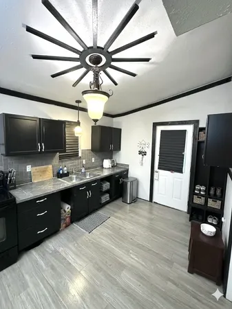 a large kitchen with a large counter space a sink and stainless steel appliances