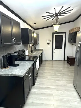 a kitchen with stainless steel appliances kitchen island granite countertop a sink and a refrigerator