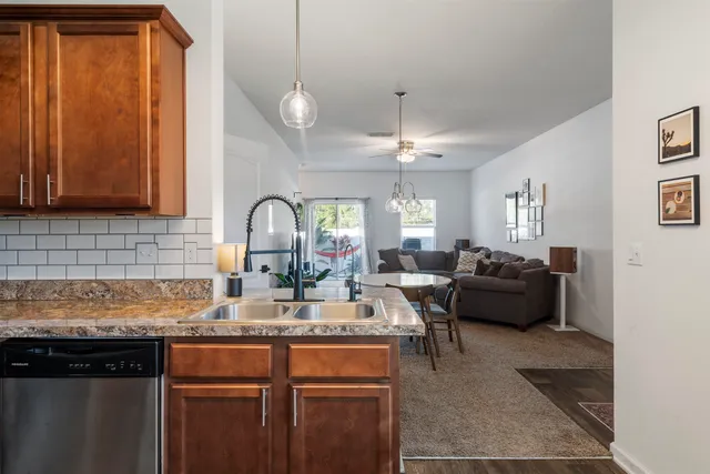 a kitchen with granite countertop a stove cabinets and wooden floor