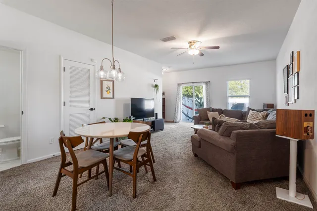 a living room with furniture a chandelier and a flat screen tv