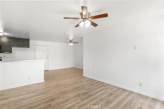a view of a room with wooden floor and a ceiling fan