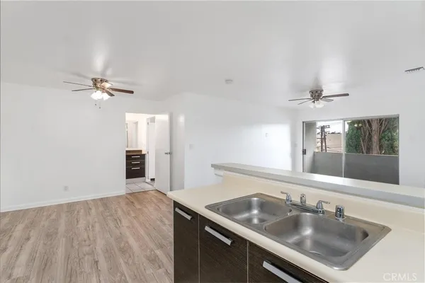 a view of a kitchen sink a faucet and cabinet