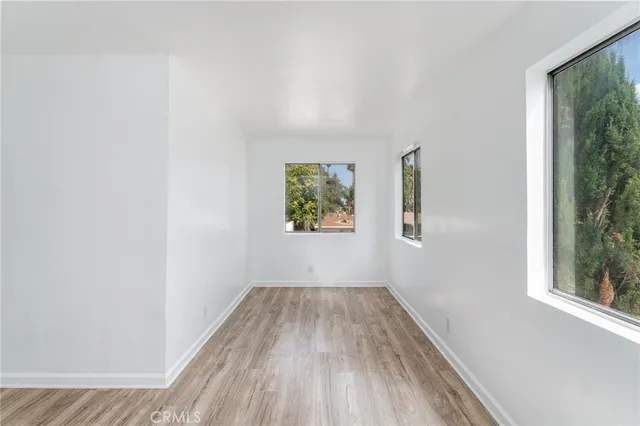 a view of a hallway with wooden floor and a window