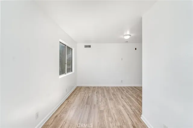 a view of a room with wooden floor and a window