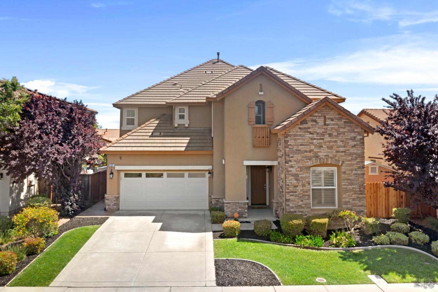 a front view of a house with a garden and plants