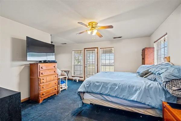 a bedroom with a bed and a flat tv screen on dresser