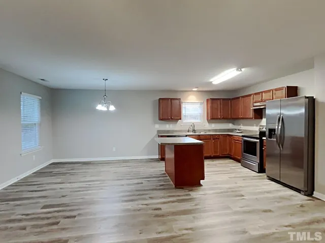 a kitchen with stainless steel appliances kitchen island granite countertop a stove top oven and granite counter tops with wooden floors