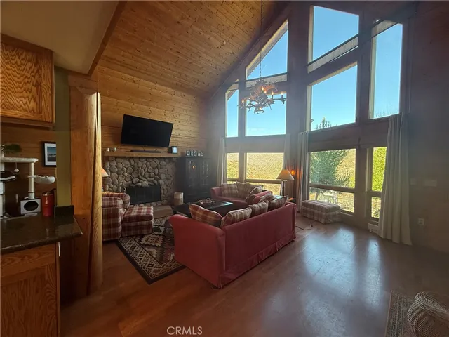 a living room with furniture a flat screen tv and entryway