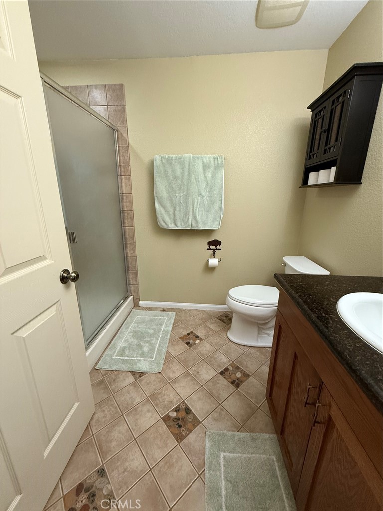 28147 North Lake Wohlford Road Valley Center, CA 92082 - Photo 10 of 26 a bathroom with a granite countertop sink toilet and shower