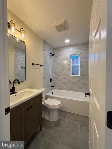 a bathroom with a double vanity sink toilet mirror and bathtub