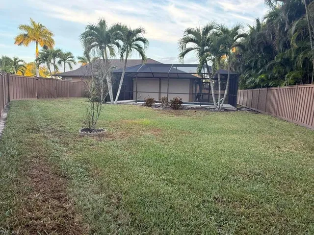 a backyard of a house with table and chairs