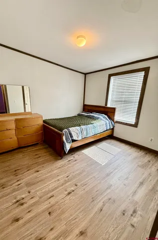 a bedroom with a bed and wooden floor
