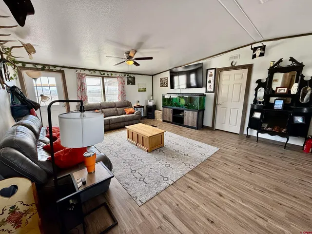 a large white kitchen with stainless steel appliances granite countertop a stove and a wooden floors