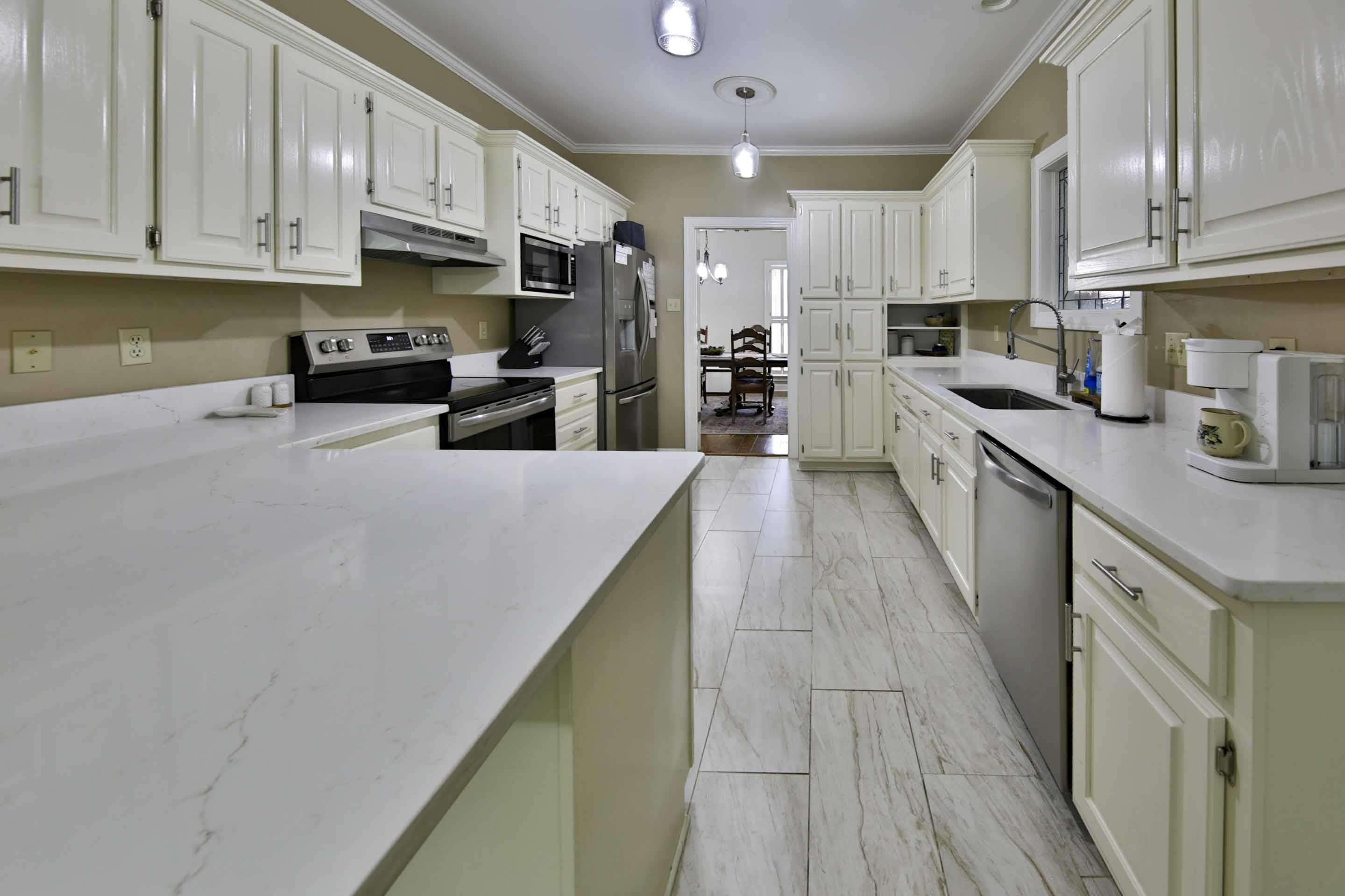104 Miller Road Covington, TN 38019 - Photo 12 of 25 Kitchen featuring white cabinetry with brushed nickel hardware, light-toned countertops, stainless steel appliances, and wood-look tile flooring