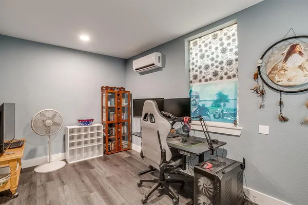 a view of workspace with wooden floor windows fan and window