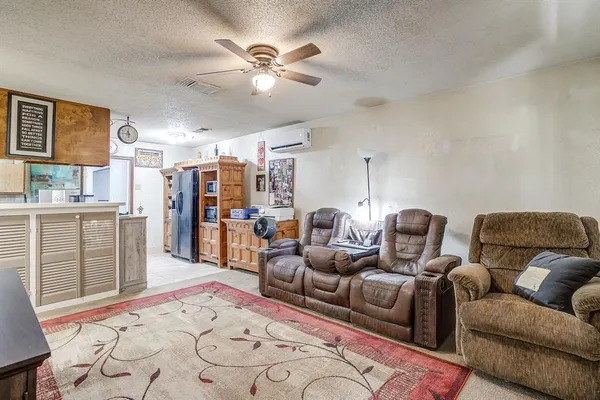 a living room with furniture a chandelier and a rug