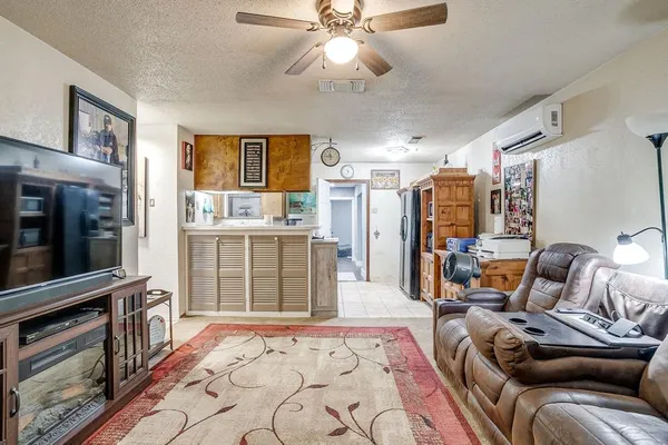 a living room with furniture a flat screen tv and kitchen view