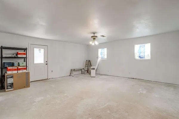 a view of an empty room with workspace and windows