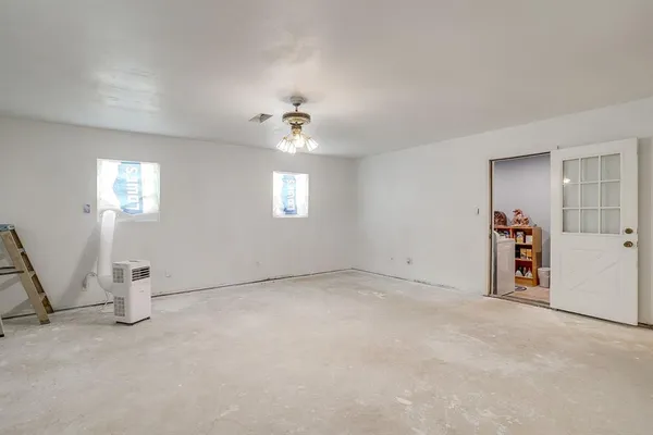 an empty room with windows and ceiling fan