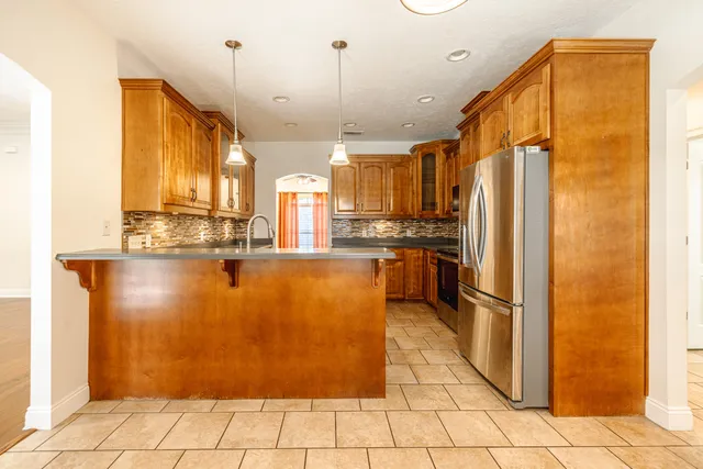 a kitchen with stainless steel appliances granite countertop a refrigerator a oven and a sink