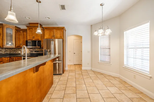 a kitchen with stainless steel appliances granite countertop a sink and a refrigerator
