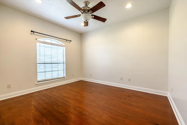 an empty room with a window and a fan
