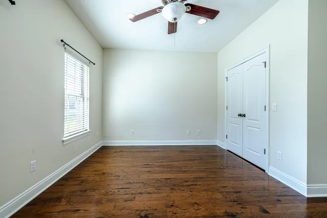 wooden floor in an empty room with a window