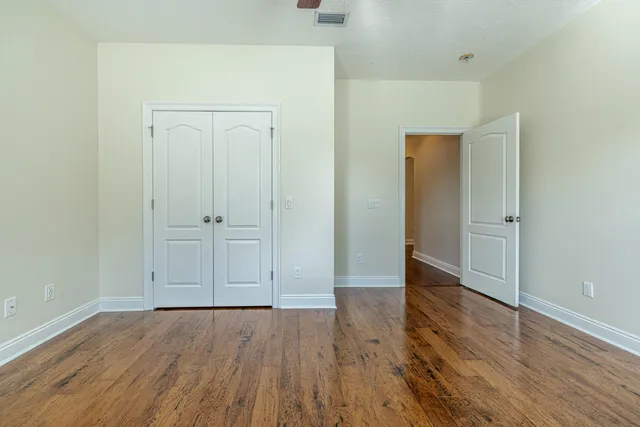 an empty room with wooden floor and closet