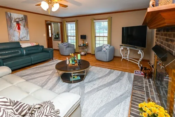 a living room with furniture a flat screen tv and a large window
