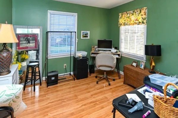 a view of a workspace with furniture and a window