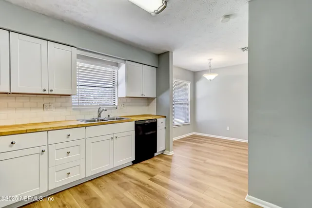 a kitchen with granite countertop white cabinets and white appliances