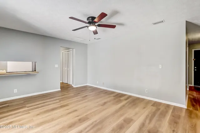a view of empty room with wooden floor