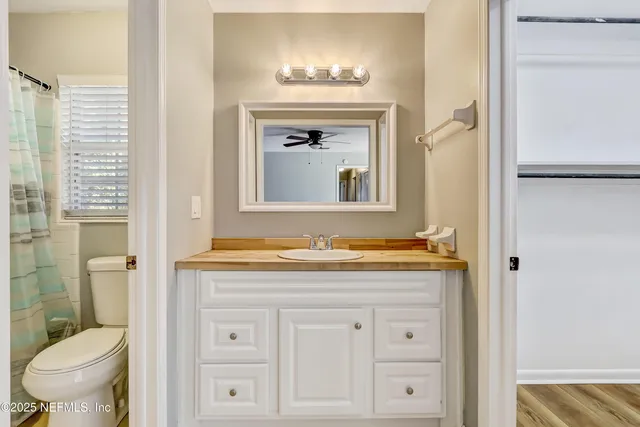 a bathroom with a granite countertop toilet sink and mirror