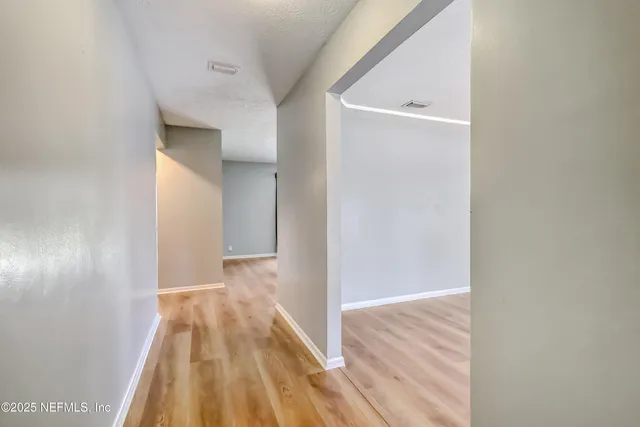 a view of a hallway with wooden floor