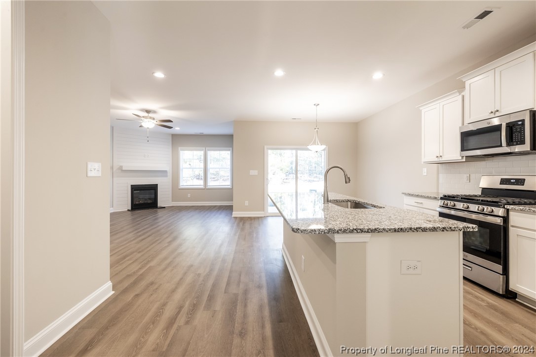 908 Westland Ridge Road Fayetteville, NC 28311 - Photo 5 of 28 a kitchen with granite countertop a sink a stove top oven and cabinetry