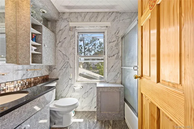 a bathroom with a toilet a sink and a window