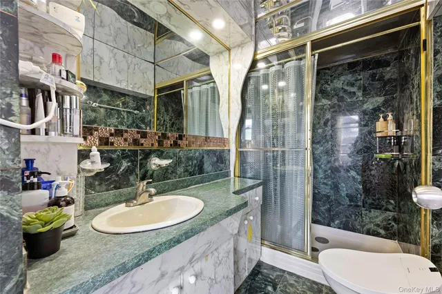 a bathroom with a sink a toilet and shower