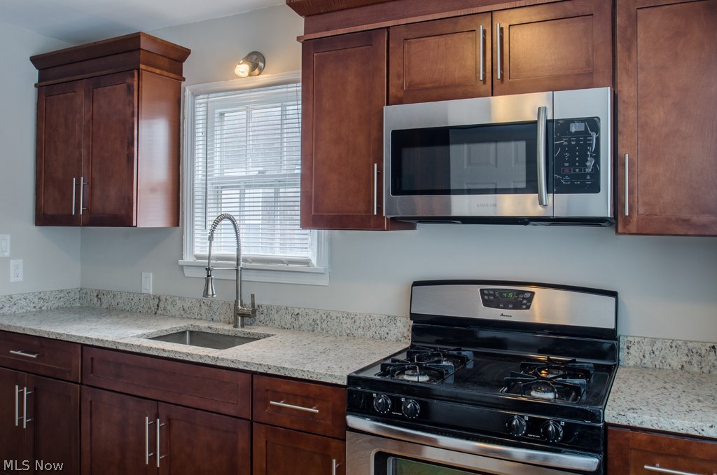 1366 Brookline Road Cleveland, OH 44121 - Photo 2 of 33 Custom Kitchen w/cognac shaker cabinetry, cloud grey granite counter tops, S.S range, microwave, Black fridge. Gleaning wood floors, newer windows