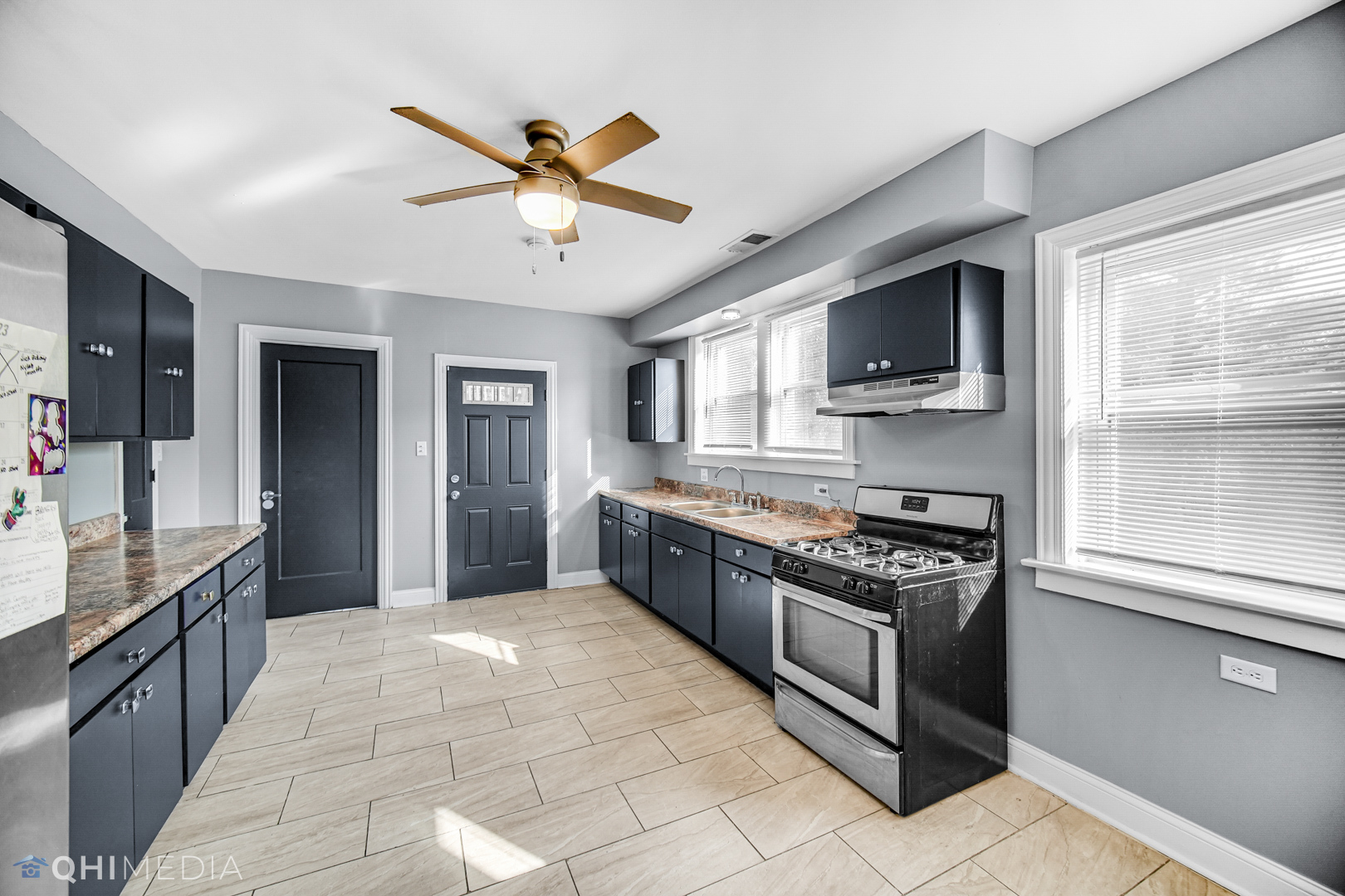 52 West 112th Street Chicago, IL 60628 - Photo 12 of 28 a large kitchen with stainless steel appliances granite countertop a stove and a sink