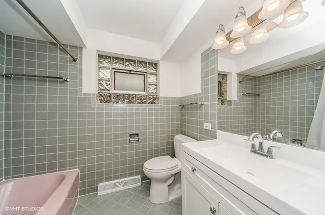 a bathroom with a sink a toilet and a mirror