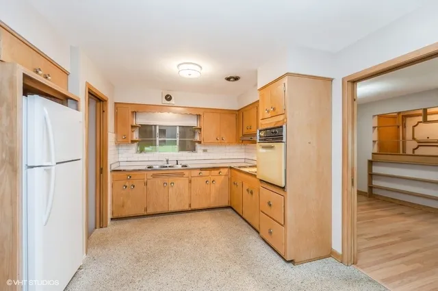 a kitchen with granite countertop cabinets and refrigerator