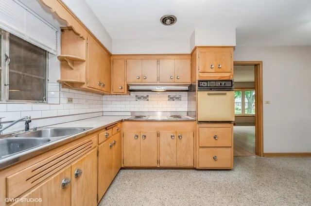 a kitchen with granite countertop a sink a stove and cabinets