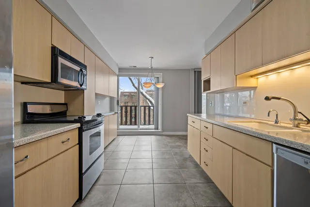 a kitchen with stainless steel appliances granite countertop a sink and a stove top oven