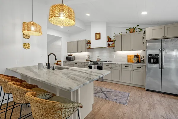 a kitchen with granite countertop a sink appliances and cabinets