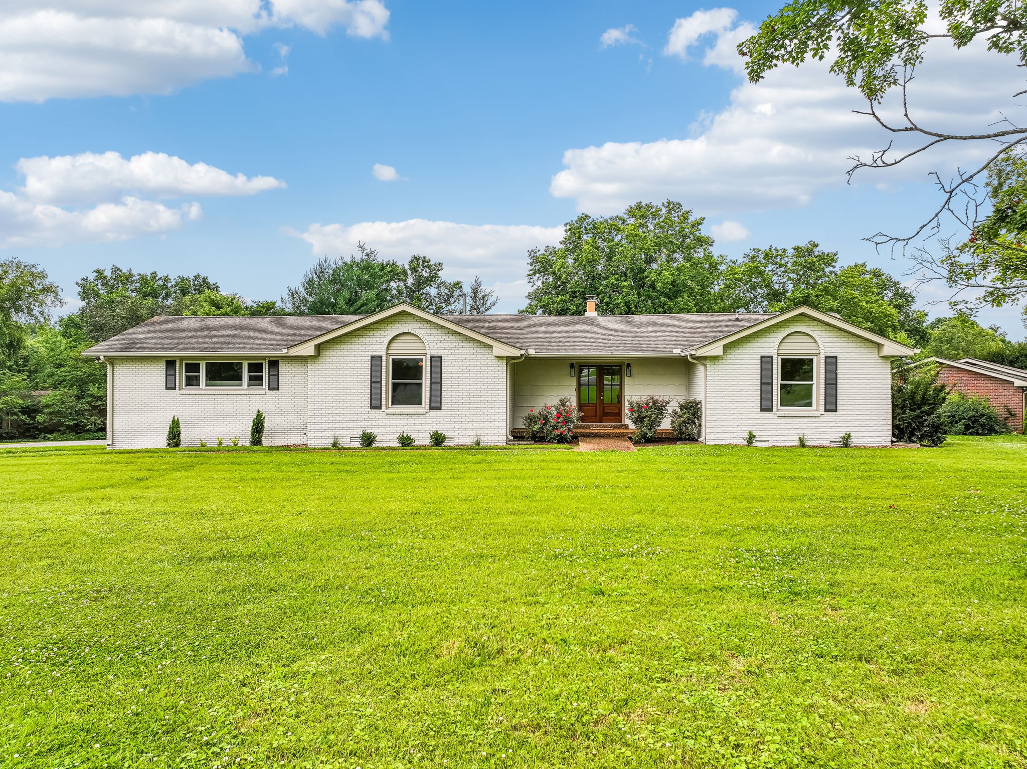a yellow and white house sitting in middle of a field
